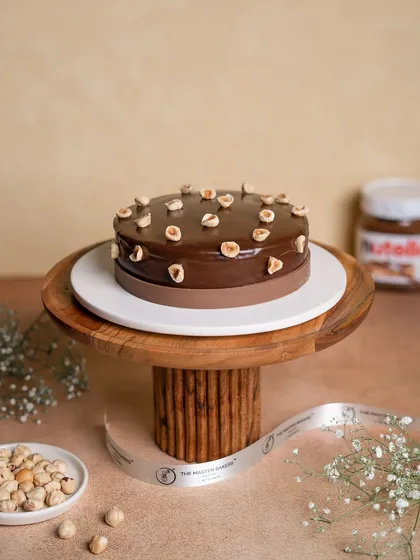 This is a chocolate and hazelnut lover's dream. Our cake is layered with moist chocolate sponge and a silky hazelnut-infused cream, then topped with a rich chocolate ganache and whole roasted hazelnuts.