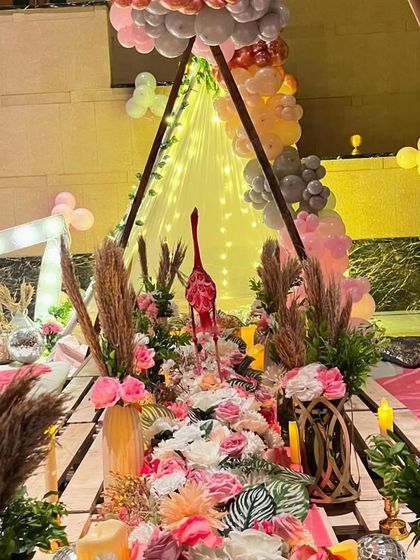 A view through the A-frame, looking down the beautifully decorated picnic table towards the light-up '17' and cozy teepee tent.
