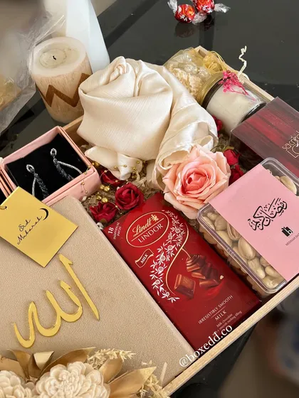 A stunning Eid gift tray curated for a special Eidi. It includes Lindt chocolates, premium nuts, a beautiful scarf, earrings, and an acrylic "Allah" cutout.