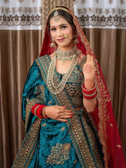 A full-length view of a student's final work: a gorgeous teal and red bridal lehenga look. This is the quality of work you'll be able to produce.