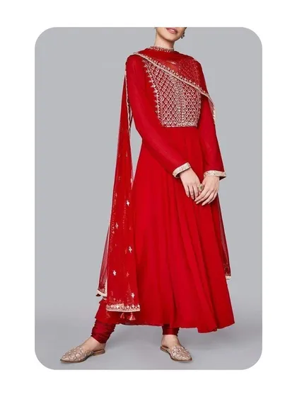 This is a classic red Anarkali suit I tailored for a festive look. It features a long-sleeved design with an intricately embroidered yoke and a flowing skirt, creating a regal and timeless silhouette.