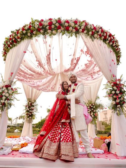 A happy couple under the mandap. The bride's hair is neatly styled to stay in place throughout the wedding rituals.