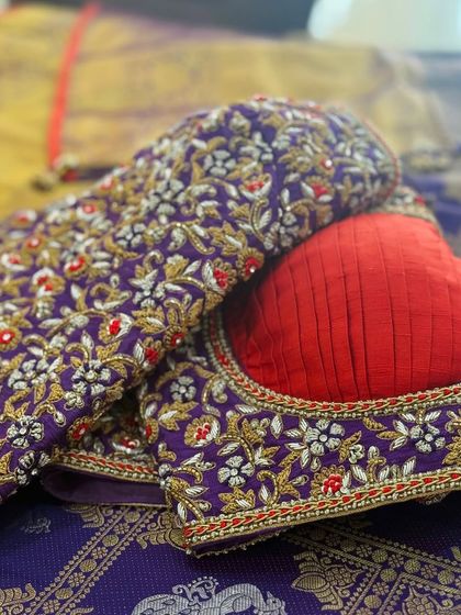 A purple blouse with red accents in the floral embroidery, featuring a unique back design.