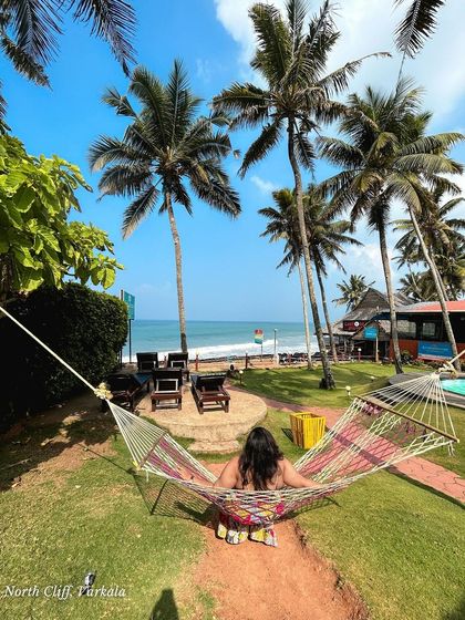 A woman relaxes in a hammock at a beautiful resort on the North Cliff of Varkala. This is the kind of peaceful, picture-perfect moment you can expect on my trips.