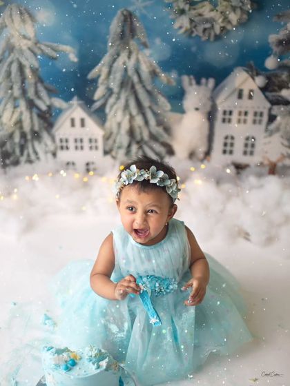 The pure joy of a first birthday! This little sweetheart absolutely loved her winter wonderland cake smash, and her happy expression is everything.