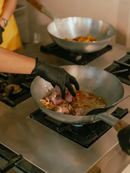 A close-up of the cooking process. We use traditional woks and fresh ingredients to create our authentic flavors.