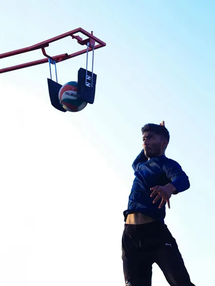 A player airborne, practicing a spike on our specialized training rig. This equipment is key for developing vertical jump and hitting power.