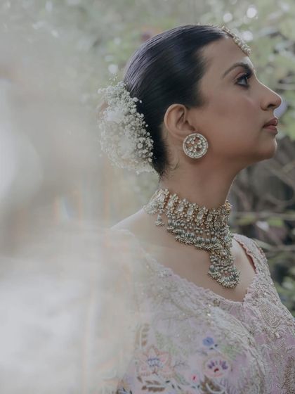 A side view of a bride with a baby's breath bun, showing its delicate texture.