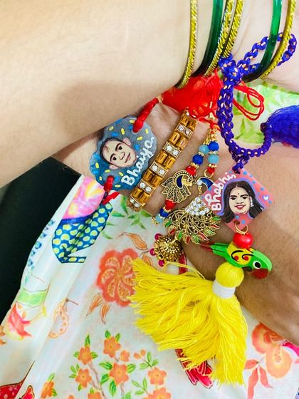 A beautiful set of matching Rakhis for a 'Bhaiya' and 'Bhabhi', complete with their portraits and colorful tassels.