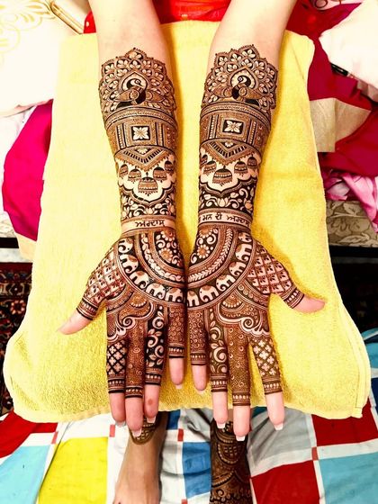 A classic bridal design with intricate details. It features peacocks, elephants, and the bride's name, Simran, written in Punjabi, adding a personal touch.