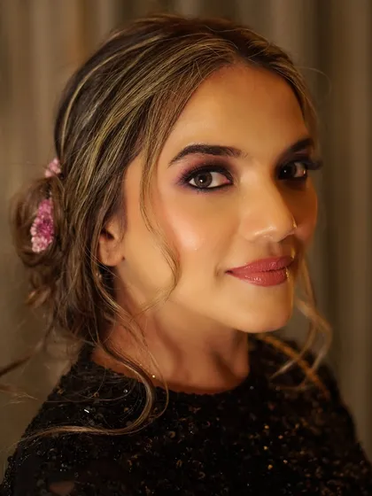 A smiling portrait that shows off a beautiful, shimmering party look. The glittery eyeshadow adds a fun and glamorous element, perfect for a night out or a special celebration.