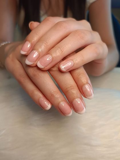 A beautifully executed classic French manicure on natural nails, showcasing a clean and timeless aesthetic.