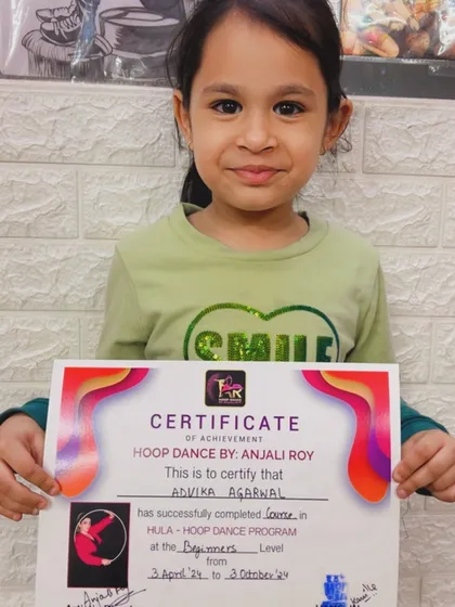 Another one of our amazing students proudly displaying her certificate of achievement for the hula hoop dance program.