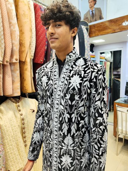 A young client confidently wearing the black and white floral embroidered sherwani, showing that great style has no age limit.