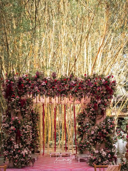 A beautiful muhurtham mandap set against a backdrop of bamboo. The stage is adorned with blush pink and white florals, creating a fairytale setting for the ceremony.