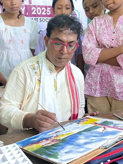 A close up shot of me demonstrating watercolor techniques to an attentive group of students. I believe in hands on teaching to help everyone learn effectively.