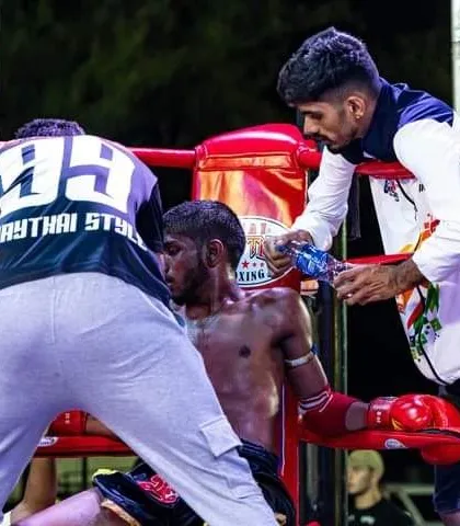 In the corner between rounds at an international fight. As a coach, my job is to guide, strategize, and keep my fighter in the battle. We win and lose as a team.