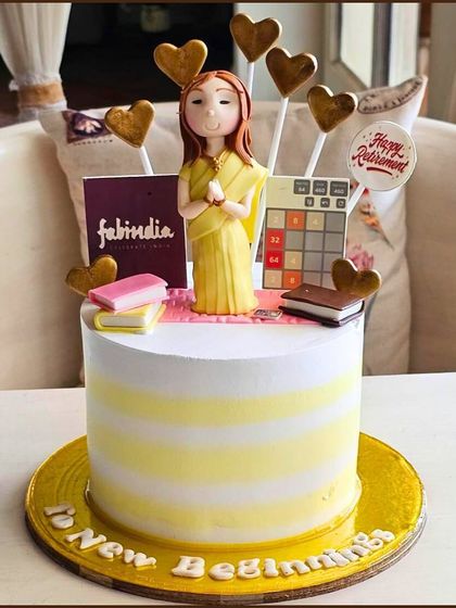 A thoughtful retirement cake celebrating new beginnings, with a personalized figure, books, and a Fabindia shopping bag.