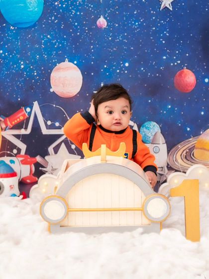 A confused little astronaut. His adorable expression adds a touch of humor to this imaginative outer space shoot.