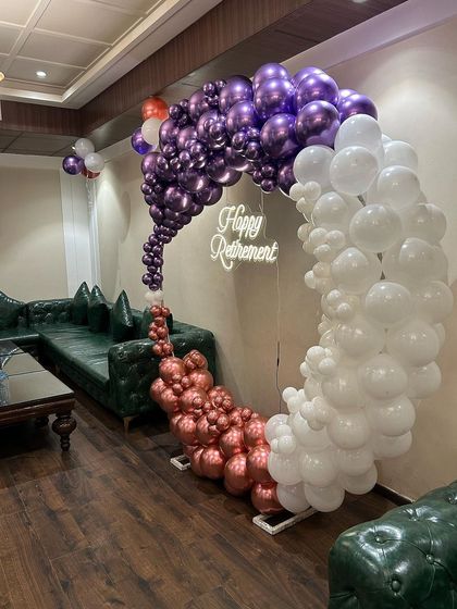 An angled view of the retirement balloon hoop, showing how it serves as a perfect photo corner within the event space.