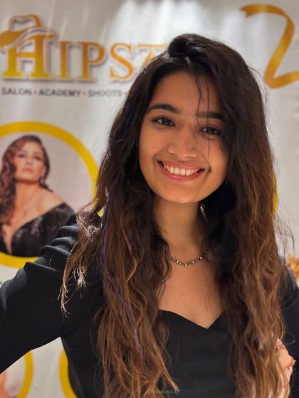 A smiling client with her new hair color. The subtle tones and soft waves create a look that is fresh, modern, and full of life.