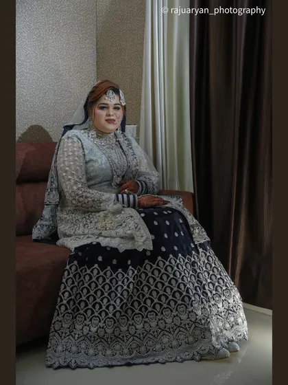 A formal seated portrait of the bride. She looks poised and confident, her beautiful wedding outfit on full display in this classic shot.