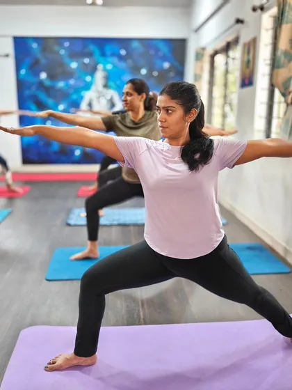 The power of a group practicing in unison is incredible. Here, our students hold Virabhadrasana II (Warrior II Pose), building strength and focus together in our sunlit shala.