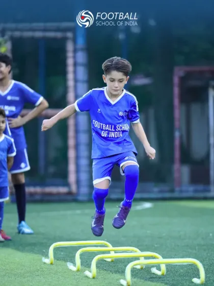Our training focuses on building complete athletes through dynamic drills. This action shot shows a young player developing agility and coordination by practicing with speed hurdles, a core part of our football skills and conditioning program.