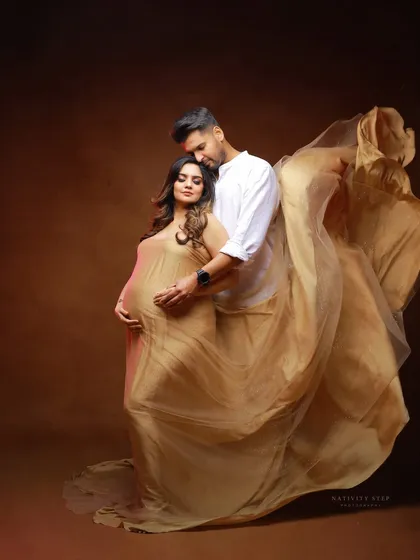 A tender moment between a couple, framed by a flowing golden gown. This shot beautifully captures the love and support in their relationship.