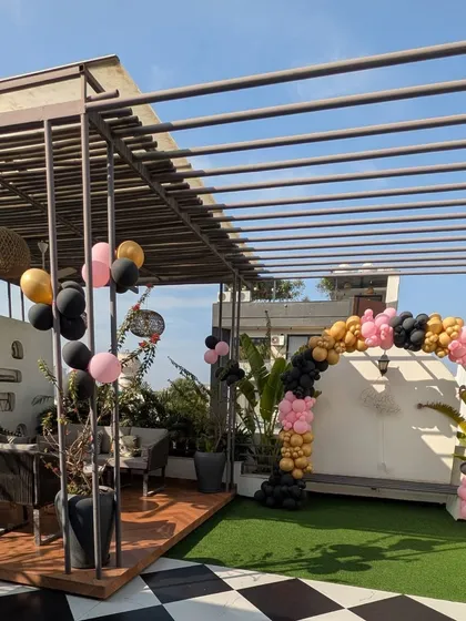 A wide shot of the terrace, showing how the balloon arch creates a perfect photo backdrop for the bachelorette party.