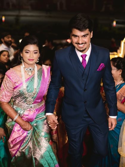 The couple making their entrance. The bride's makeup is designed to look stunning under the bright lights of the reception hall.