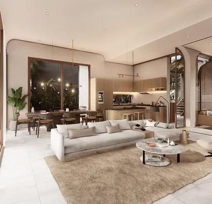The interior of a Vagator villa showcases an open-plan living, dining, and kitchen area with earthy finishes and soft, neutral tones. Large sliding glass doors connect the space directly to the pool deck, promoting a relaxed, indoor-outdoor lifestyle.