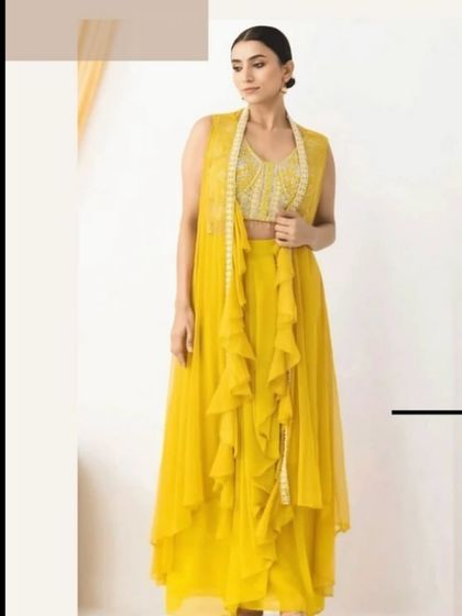 A full-length view of the yellow Indowestern outfit, showing the unique silhouette with the ruffled cape and dhoti pants.
