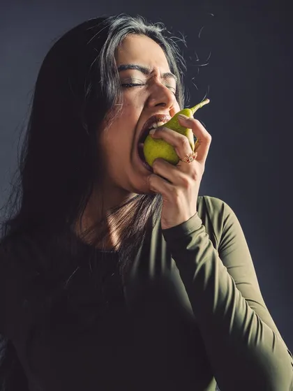 A moment of sensory experience. This shot is about taste and texture, conveyed through the model's expression.