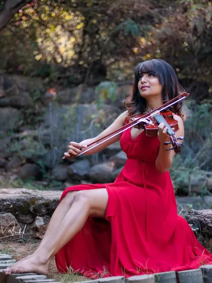 I wanted to define the word 'class' in a picture. This shot from our violinist series, with the model in a flowing red dress seated gracefully on stone steps, captures a feeling of pure elegance and artistry.