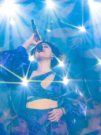 An artistic shot of Sunidhi under a starburst of lights, a moment of pure performance magic.