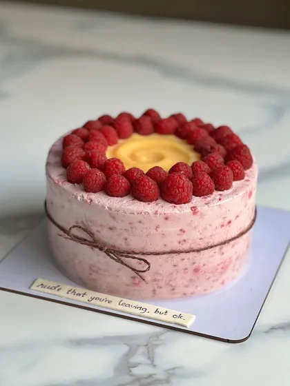 A lovely Lemon Raspberry cake with a rustic twine bow. The message on the side reads, "sad that you're leaving, but ok." Cakes are perfect for farewells too!