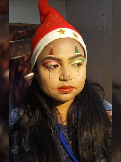 A full-face view of the jester-inspired Christmas makeup. This look combines graphic elements on the cheeks with blended eyeshadow, showcasing a range of techniques.