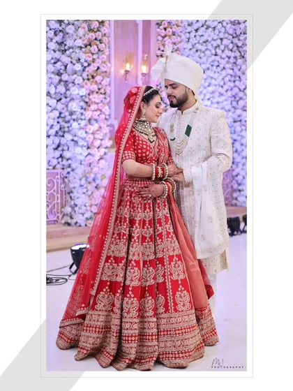 Another beautiful full-length couple portrait, showing the bride's stunning lehenga and the elegant decor.