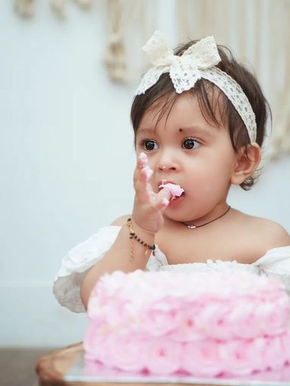 A close-up of the birthday girl enjoying her cake. These are the sweet, messy details that make cake smash photos so special.