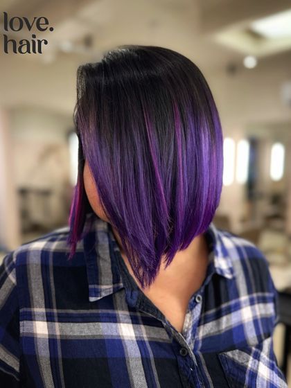A sleek and sharp purple bob. This look features a vivid purple balayage on a perfectly cut asymmetrical bob for a high-fashion, geometric look.