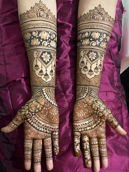 An elegant bridal design featuring beautiful hanging jhumkas and delicate floral bands. The combination of bold figures and fine, detailed fillers gives this mehendi a balanced and sophisticated look.
