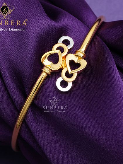 A playful and romantic gold bracelet featuring interconnected hearts. The open-cuff design is both modern and easy to wear, making it a popular choice for younger customers.