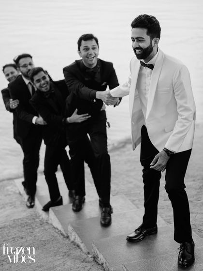The groom and his groomsmen sharing a laugh. This black and white candid shot perfectly captures the camaraderie and joy of the moment.