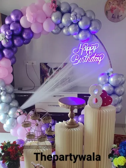 A beautiful ring decoration with pastel purple and pink balloons, accented with silver. The neon sign and light-up number "8" make it perfect for a stylish birthday.