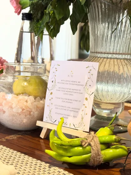 A detail shot from the 'Nazar na lage' theme, featuring traditional protective elements like lemons, green chillies, and a jar of pink salt, presented in a stylish and modern way.