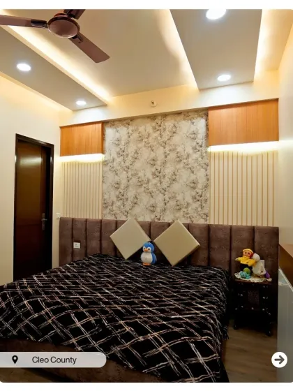 A bedroom design that plays with textures. The combination of a tufted headboard, fluted panels, and floral wallpaper creates a rich and layered aesthetic.