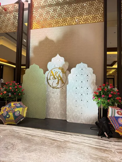 This photo shows a unique photo booth I designed, featuring elegant mirror-work panels in traditional arch shapes. Paired with colorful Rajasthani umbrellas, it provided a beautiful backdrop that blended modern aesthetics with cultural design.