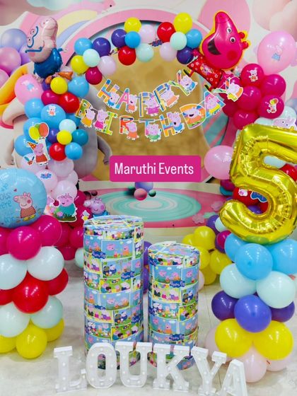 A bright and cheerful Peppa Pig theme for a 5th birthday. This setup uses primary colors, themed plinths, and a large number balloon to create a playful scene.