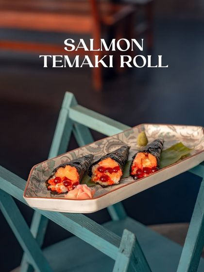 The Salmon Temaki Roll, a hand-rolled cone of indulgence, filled with crisp nori and a hint of spiced mayo.